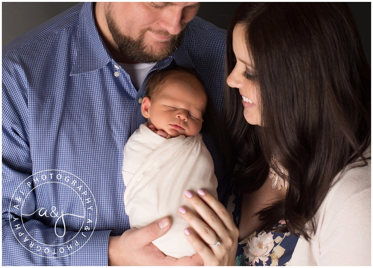 newborn boy swaddled with parents
