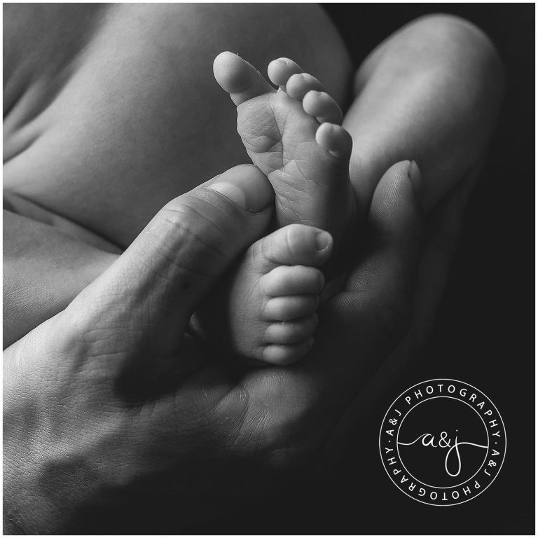 baby-feet-dads-hands-black-white-photo