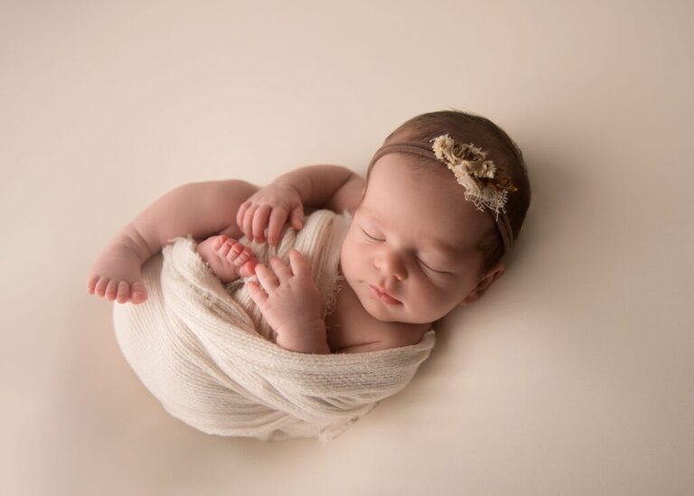 newborn-baby-swaddled-neutral-accessories-blush-background