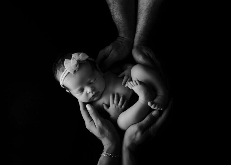 newborn-cradled-mom-dad-hands